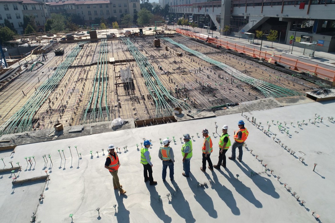 A construction crew reviewing groundwork and structural rebar on site